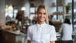 Portrait of smiling businesswoman standing in cafe. Beautiful young woman in office.