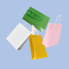 Wall Mural - Colorful shopping bags falling on light blue background
