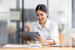 © David - Young happy business asian woman working with tablet in corporate office