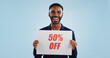 © Wesley JvR/peopleimages.com - Excited man, portrait and sale sign for advertising, deal or discount against a blue studio background. Happy male person showing billboard or poster for marketing, promotion or special on mockup