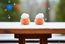 Twin Snowballs On A Picnic Table With Snowfall