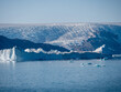 Eisberg in einem grönländischen Fjord mit Gletscher im Hintergrund