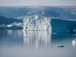 Eisberg in einem grönländischen Fjord mit Gletscher im Hintergrund