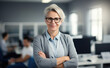 © Sascha - Confident professional woman with silver hair and glasses smiling.
