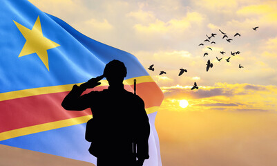 Silhouette of a soldier with the DR Congo flag stands against the background of a sunset or sunrise. Concept of national holidays. Commemoration Day.