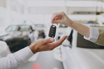 Wall Mural - Cropped photo of male customer buyer client receive car keys fob keyless system from salesman choose auto want buy new automobile in showroom vehicle salon dealership store motor show. Sales concept.