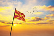 Waving flag of Macedonia against the background of a sunset or sunrise. Macedonia flag for Independence Day. The symbol of the state on wavy fabric.