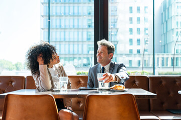 Wall Mural - Business people meeting in a business park - Corporate businessmen and businesswoman bonding outdoors, colleagues meeting after work in a bar cafeteria