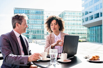 Wall Mural - Business people meeting in a business park - Corporate businessmen and businesswoman bonding outdoors, colleagues meeting after work in a bar cafeteria