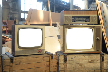 Two old TVs with white isolated screens in a hangar. Retro technology concept.