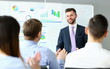 Portrait of general manager talking about annual report. Speaker looking at colleagues with gladness. Company and business meeting concept. Blurred background