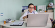 © Nadzeya - Doctor communicates remotely from laptop with patients or doctors via Internet via video call