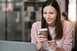 © NINENII - portrait of a business woman Self-confident young woman sit holding coffee mug and working laptop.  Casual business. Self-confidence.