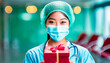 Portrait of Asian female doctor holding a gift box in the hospital