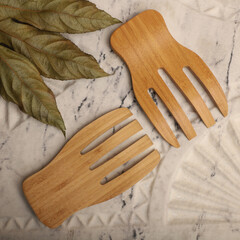 Wall Mural - Wooden salad hands, bamboo kitchen utensils, bamboo salad hands, wooden salad spoons, close-up and concept shot. e-commerce photos, free space for writing,