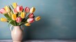Vibrant yellow and pink tulips in a ceramic vase on a blue background