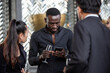 © winnievinzence - Group of diverse office people holding glasses of wine using mobile, talking and sharing connection at the company party. Employee enjoy gathering at the event after work
