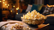 Transparent big bowl with sweet or salty popcorn on a table in front of a tv-set and a remote control. Cozy film night and snack time at home