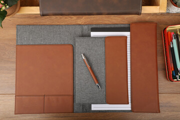 Leather and fabric flap portfolio. Concept shot, top view, flap portfolio in brown colors and leather pen. Custom background flap portfolio view. Flap portfolio and accessories.