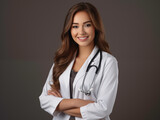 Fototapeta  - Profil atrakcyjnego młodego lekarza ubranego w biały fartuch medyczny ręce skrzyżowane, stetoskop, uśmiechnięty szary kolor tła 