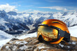 Ski helmet and goggles with reflection of mountains against the backdrop of scenic snowy mountain tops. Winter ski and snowboarding vacation concept.