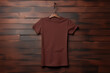 Blank brown t-shirt with hanger on wooden wall background. Top view of t-shirt mock up template for design print