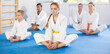Family during group karate training with trainer in gym performs stretching of muscles by performing butterfly exercise