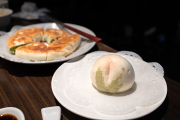 Wall Mural - Chinese bun and pan cake on a white plate in a restaurant
