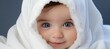 curious toddler with blue eyes peeking from under white blanket, copy space for text placement