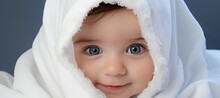 Curious Toddler With Blue Eyes Peeking From Under White Blanket, Copy Space For Text Placement
