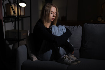 Canvas Print - Depressed young woman in dark room at night