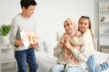 Canvas Print - Little children greeting their Muslim mother with gifts in bedroom