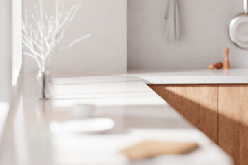 A bright beige-toned kitchen interior with sunlight 
coming through the window.