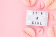 It's a girl. Lightbox with letters and tissue paper balls in a pink color. Baby shower composition with copy space.