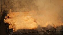 한국 전통음식 돼지갈비를 여러 개의 석쇠로 동시에 구워내고 하얀 연기가 자욱한 