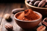 Cocoa powder in a bowl and cocoa beans on wooden background