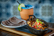Queso Fundido. Oaxaca and chihuahua cheese on a
skillet with chorizo and pico de gallo, served with blue corn tortillas