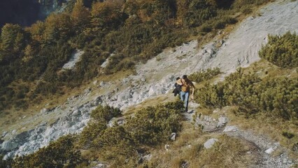 Wall Mural - Man traveler walks through the forest to the mountains. Incredibly beautiful views in the Alpine mountains. Hiking route in the Alps mountains in autumn