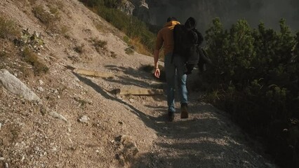 Wall Mural - Man traveler walks through the forest to the mountains. Incredibly beautiful views in the Alpine mountains. Hiking route in the Alps mountains in autumn