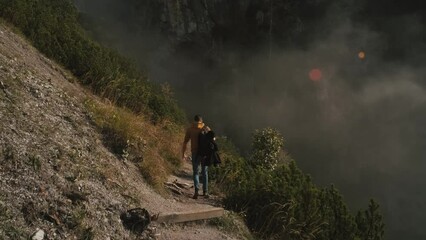 Wall Mural - Man traveler walks through the forest to the mountains. Incredibly beautiful views in the Alpine mountains. Hiking route in the Alps mountains in autumn