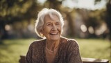 Fototapeta  - The portrait of a happy retired elderly woman smiling and laughing shot outdoors on a sunny day