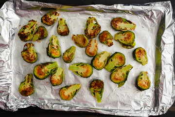 Wall Mural - Roasted Brussels Sprout Haves on a Foil-Lined Sheet Pan: Browned baby cabbages on a cookie sheet covered with aluminum foil