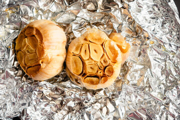 Wall Mural - Roasted Heads of Garlic on Crumpled Aluminum Foil: Roasted garlic bulbs drizzled with extra virgin olive oil and sea salt on tin foil