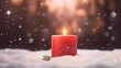 A single red candle is lit in the snow with a blurry background of trees and snow flakes