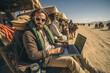 A man programmer coding sitting in the desert with a laptop. Working remote on computer outdoor.
