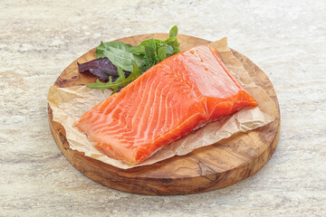 Raw salmon fillet over board