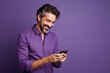 man looking at phone standing isolated on purple background