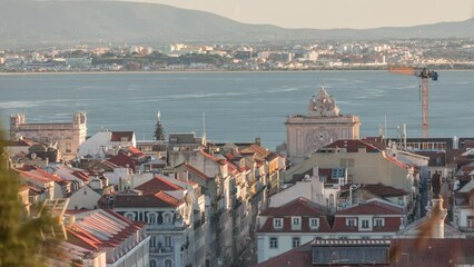 Wall Mural - Aerial view of Lisboa downtown timelapse during sunset. Panoramic of Baixa, Rossio and Chiado red rooftops from above. Arch on the Augusta street. Almada on the other side of Tejo river. Portugal