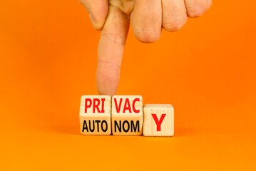 Wall Mural - Privacy or autonomy symbol. Concept word Privacy or Autonomy on wooden cubes. Beautiful orange table orange background. Businessman hand. Business privacy or autonomy concept. Copy space.