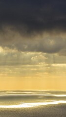 Wall Mural - timelapse of dark stormy sky and moving clouds, sea and penetrating sunlight. vertical video